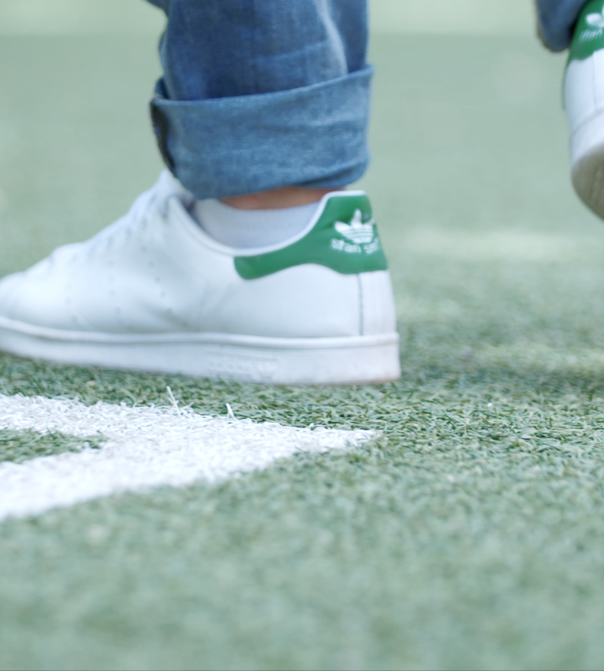 Inzoomade sneakers på en fotbollsplan