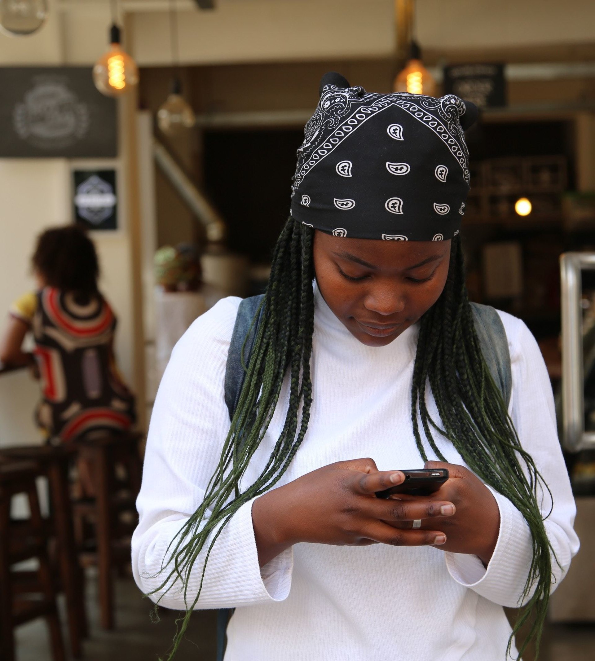 girl holding phone at cafe